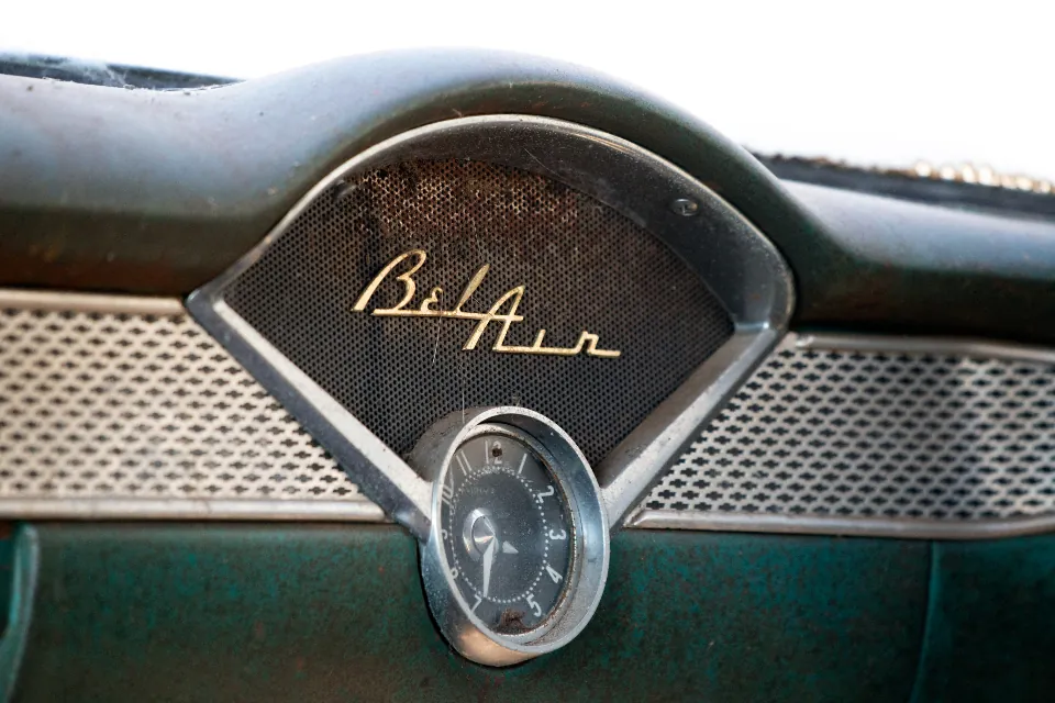 A restored vintage car dashboard with chrome script and dial detailing